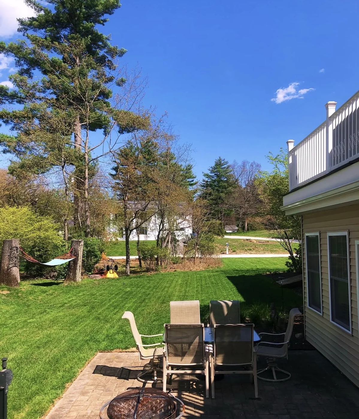 Backyard patio with a freshly cut green lawn