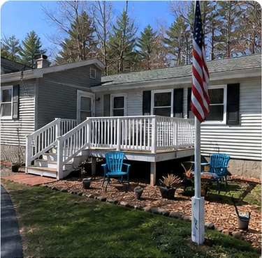 Freshly cleaned yard with landscaping beds and a white deck