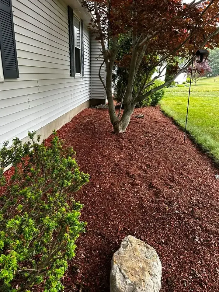 Fresh red mulch installed beside a home